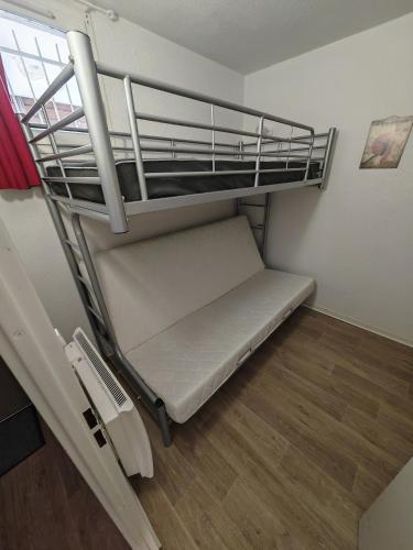 Cette petite chambre dispose de lits superposés et d'une échelle. dans l'établissement Appartement Alpe D'huez, à Huez