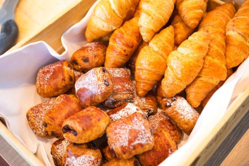 a tray filled with pastries and croissants at Garner Hotel Berlin - Schöneberg by IHG in Berlin