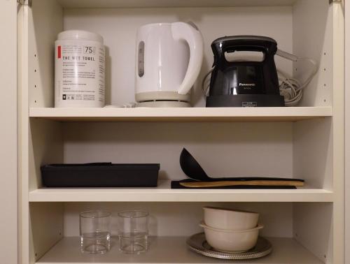 a cupboard filled with lots of kitchen utensils at ROOMs 001 カフェ併設 綺麗なワンルーム 分倍河原駅から徒歩3分 in Fuchu