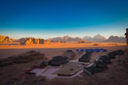 an aerial view of a desert with mountains in the background at Mars Land Luxury Camp in Wadi Rum