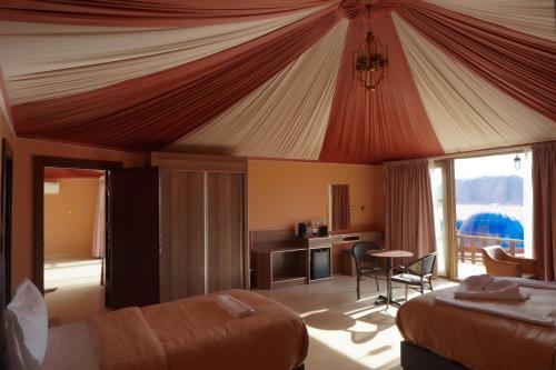 a bedroom with a tent with a bed and a desk at Mars Land Luxury Camp in Wadi Rum