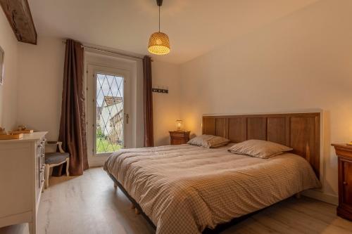 a bedroom with a large bed and a window at Le Francvillois in Villefranche-Sur-Cher