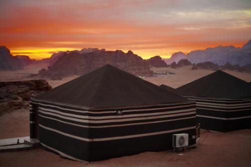two black and white tents in the desert at Mars Land Luxury Camp in Wadi Rum