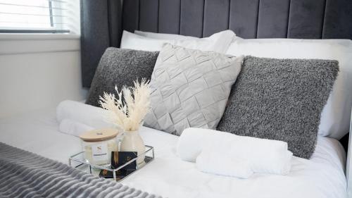 a bed with pillows and a night stand on it at Luxury 2 Guest House, Parking with EV , WIFI AND NETFLIX in Coventry
