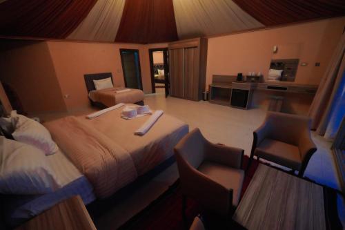 a hotel room with a bed and two chairs at Mars Land Luxury Camp in Wadi Rum
