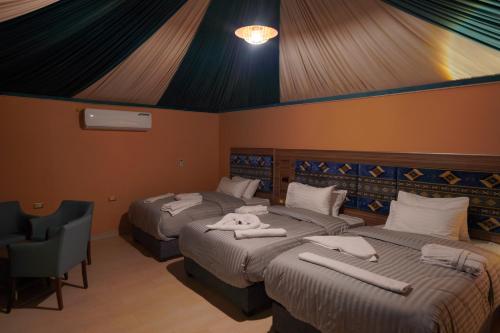 a bedroom with two beds with towels on them at Mars Land Luxury Camp in Wadi Rum