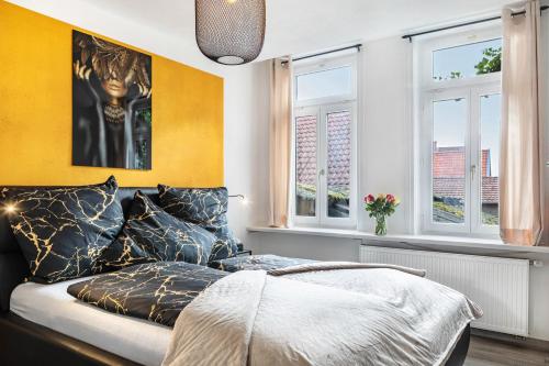 a bedroom with a bed and two windows at Marktplatz Ferienwohnung in Alsfeld