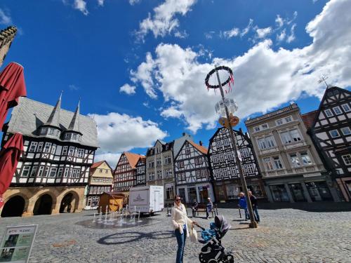 a woman with a stroller in a town with buildings at Marktplatz Ferienwohnung in Alsfeld