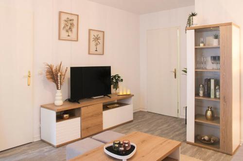 un salon avec une télévision à écran plat sur une armoire dans l'établissement Nice T3 with furnished balcony in Saint-Denis, à Saint-Denis