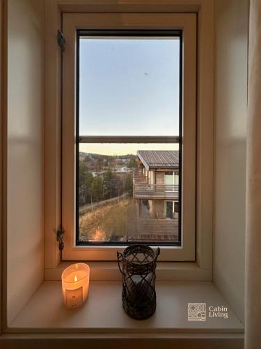 a window with a candle and a candle holder at Modern apartment Hovden ski in-out x-skiing, 2 bathrooms and balcony in Hovden