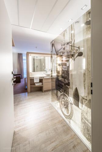 a room with a bathroom with a bike on a wall at Arkadenhaus - Hotel Freiherr von Schwarzenberg in Papenburg