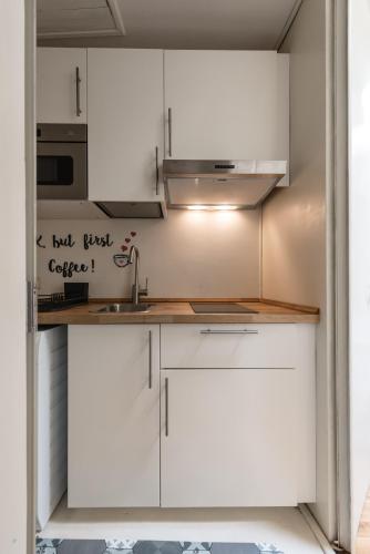 a kitchen with white cabinets and a sink at Single House in Pisa