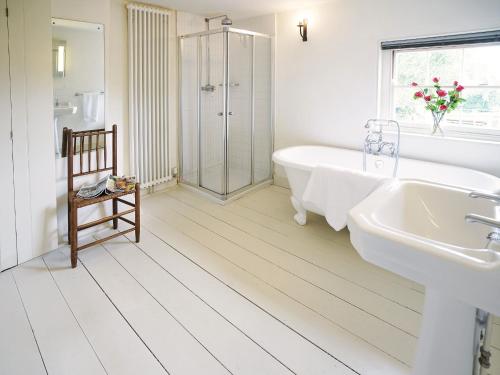 a white bathroom with a tub and a sink at Hidden Cottage by The Suffolk Cottage Collection in Aldeburgh