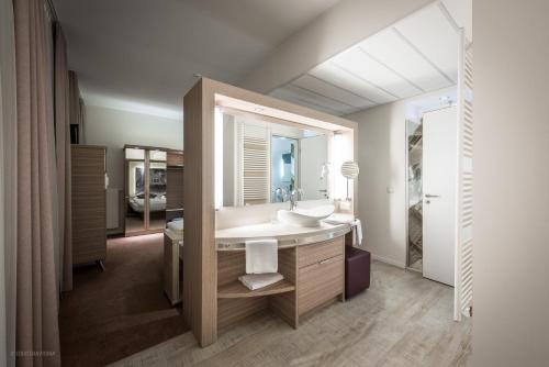 ein Badezimmer mit Waschbecken und Spiegel in der Unterkunft Arkadenhaus - Hotel Freiherr von Schwarzenberg in Papenburg