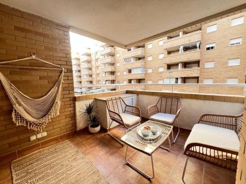 a balcony with chairs and a hammock on a building at Paraiso en la playa con terraza in El Borseral