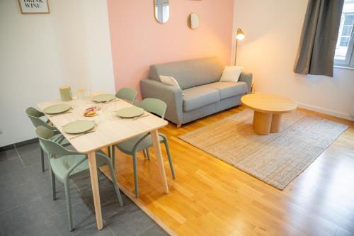 a living room with a table and a couch at Rosalie - Bienvenue dans le cœur historique de Troyes in Troyes