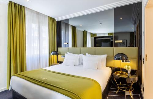 a bedroom with a large bed with a green headboard at Altis Avenida Hotel in Lisbon