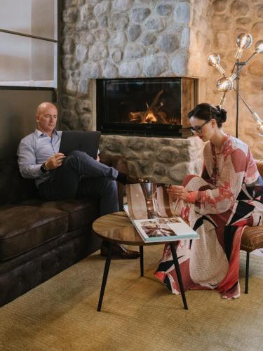 a man and a woman sitting in a living room with a laptop at Lake Hotel La Pieve in Pisogne