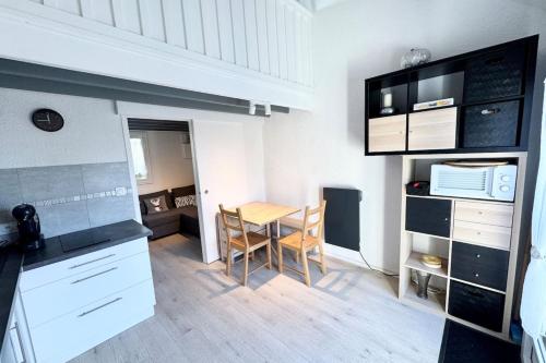 une cuisine avec une table et une salle à manger dans l'établissement Jolie maisonnette - 300m des plages piscine, à Guidel