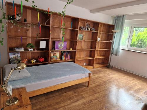 a bedroom with a bed with wooden shelves at Dom blisko lotniska i Areny Tarczyńskiego in Wrocław