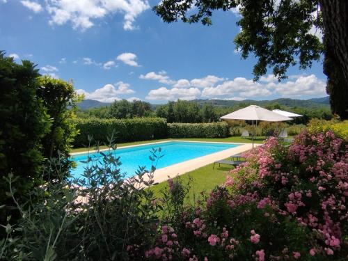 a pool in the garden of a house with flowers at Tenuta San Jacopo - Agriturismo in Cavriglia