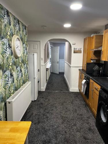 a kitchen with a refrigerator and a clock on the wall at Levy Nook House 1 bed apartment 5 minute walk to Stockton town centre & Free Parking in Stockton-on-Tees