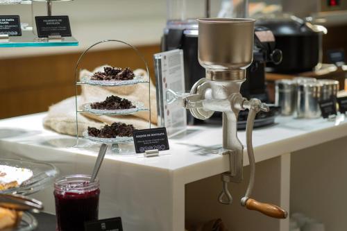 a table with some cakes and a mixer on it at Barcelona Hotel Colonial in Barcelona
