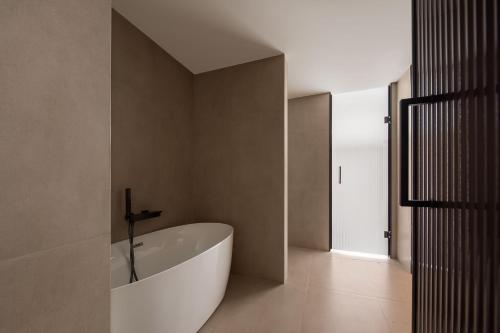a bathroom with a white bath tub in a room at Atour Hotel Haikou Longhua Jinniuling Park in Haikou