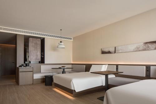 a hotel room with two beds and a couch at Atour Hotel Haikou Longhua Jinniuling Park in Haikou