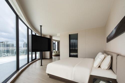 a hotel room with a bed and a flat screen tv at Atour Hotel Haikou Longhua Jinniuling Park in Haikou