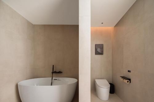 a bathroom with a white tub and a toilet at Atour Hotel Haikou Longhua Jinniuling Park in Haikou