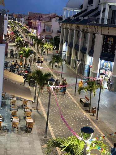a city street with people and tables and buildings at Tropical Suite 22 B in Santa Maria