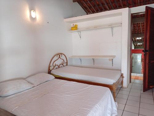 une chambre avec deux lits et une fenêtre dans l'établissement Casa Jangada - Incrível vista mar com Piscina e a melhor localização na Beira Mar da Taíba, à Taíba