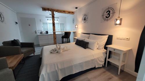 a bedroom with a white bed and a living room at Chabelas Mini Loft in La Lajita
