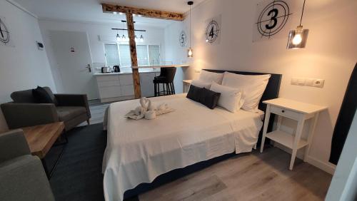 a bedroom with a white bed and a living room at Chabelas Mini Loft in La Lajita