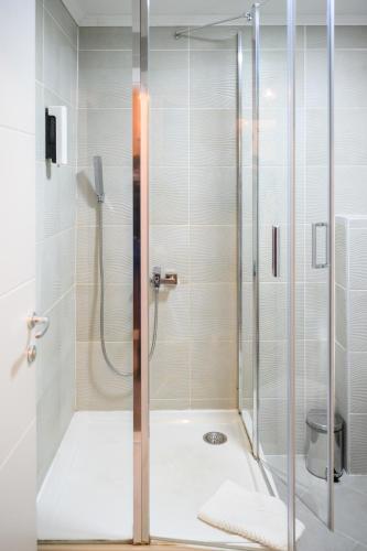 a shower with a glass door in a bathroom at MV Monogram in Inđija