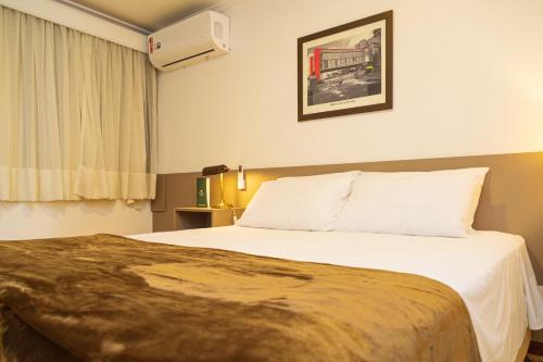 a hotel room with a bed and a window at Transamerica Executive Higienópolis in Sao Paulo