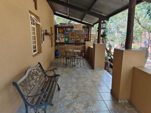 a porch with a bench and a table and chairs at Cave View self catering cottages in Beckedan