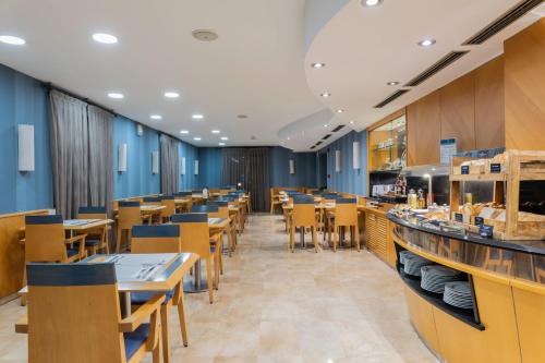 a restaurant with blue walls and wooden tables and chairs at Hotel del Mar in Barcelona