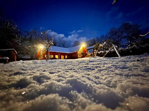 a house in the snow at night at ADORA River Retreat in Avrig