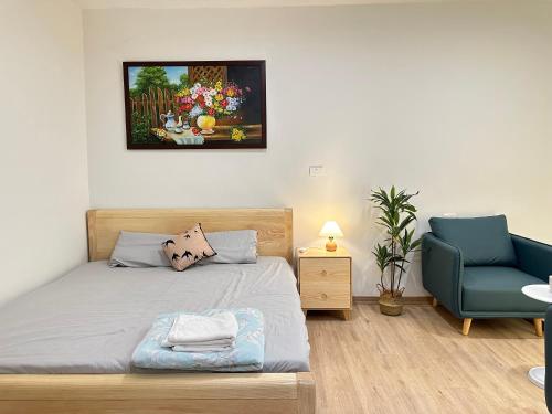 une chambre avec un lit et une chaise bleue dans l'établissement Nhà DK 2, à Hanoï