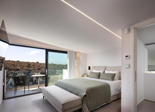 a bedroom with a bed and a large window at Blue Olive Luxury Villa in Kounoupidhianá