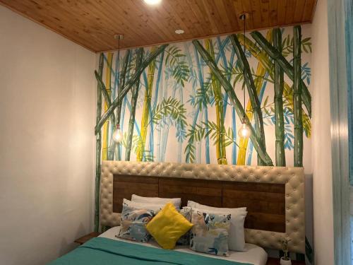 a bedroom with a bed with a mural of bamboo at Hotel Boutique Stay La 10 in Medellín