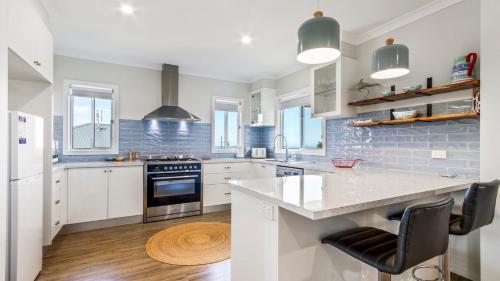 a kitchen with white cabinets and a counter top at Waves and Blossoms in Cunninghame