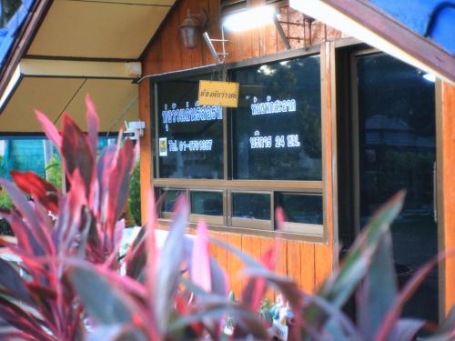 a restaurant with a window and plants in front of it at Thungwua laen resort in Chumphon