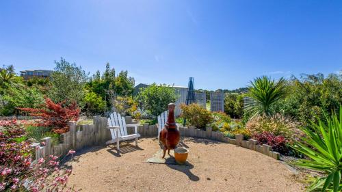 a statue of a cat sitting in a garden at Waves and Blossoms in Cunninghame