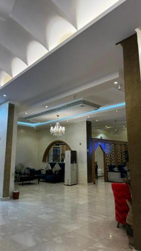 a large lobby with a room with couches and a chandelier at شقق لافينا للشقق المخدومة التصنيف اقتصادي in Sakakah