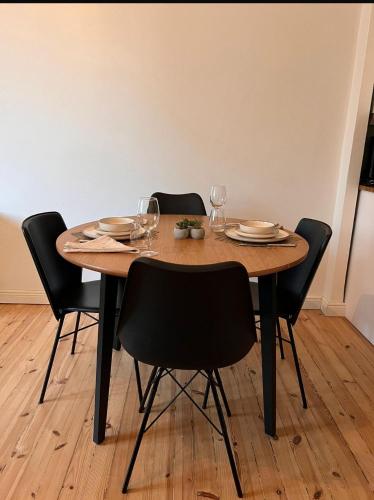 a dining room table with chairs and plates and wine glasses at Your Chic Vibrant APT in Helsinki