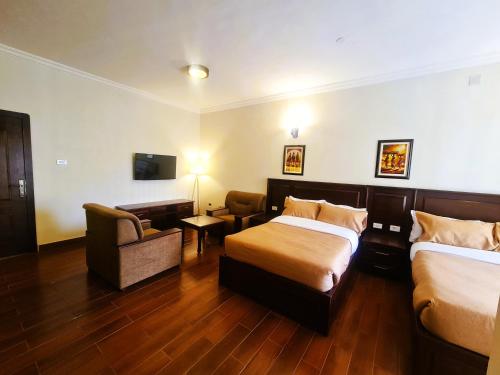 a hotel room with two beds and a chair at FBK Guest House in Addis Ababa