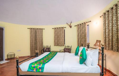 a bedroom with a large bed with green pillows at Treebo Premium Mowgli's Den, Pench in Khawāsa